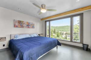 Primary Bedroom featuring massive windows, finished concrete flooring, recessed lighting, and a ceiling fan
