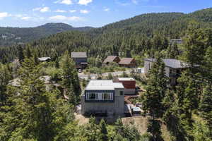 View of subject property featuring a forest and a mountainous background