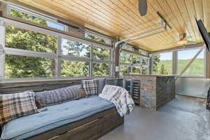 Sunroom / solarium featuring wine fridge, rollup windows, fans and TV