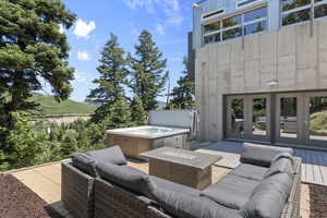 View of patio featuring a hot tub, french doors, an outdoor hangout area, and a deck