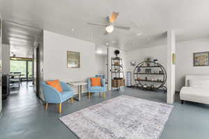 Living area with ceiling fan, finished concrete flooring, and recessed lighting