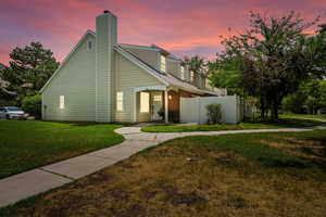 View of front of home with a chimney and brick siding