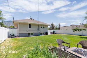Rear view of house featuring a fenced backyard