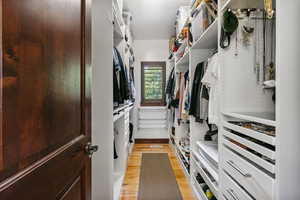 Primary walk in closet featuring built in storage