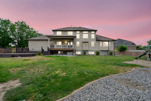 Rear view of house with stucco siding, a wooden deck, and a shingled roof