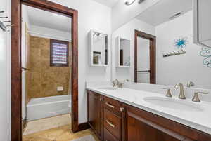 Full bath with double vanity, tub / shower combination