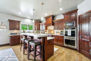 Kitchen with stainless steel appliances, premium range hood, light countertops, decorative backsplash, and recessed lighting