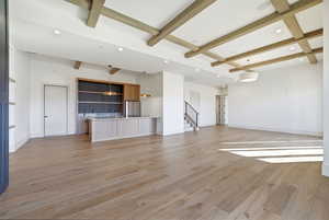 Unfurnished living room featuring beam ceiling, light wood-style flooring, recessed lighting, and coffered ceiling