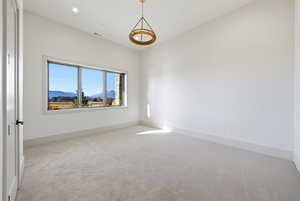 Carpeted spare room with a mountain view and recessed lighting