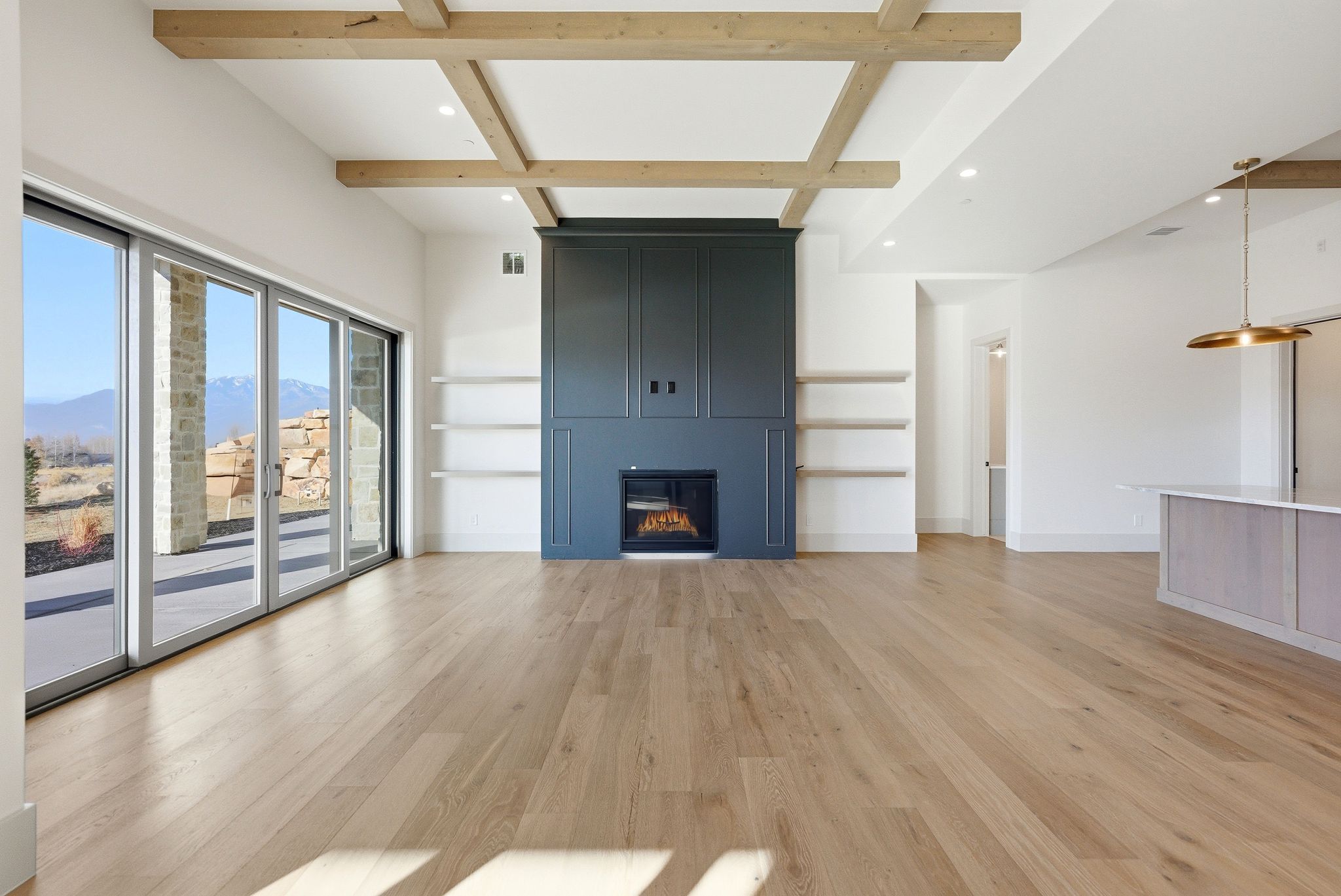 Unfurnished living room featuring beam ceiling, recessed lighting, light wood-style floors, coffered ceiling, and a fireplace
