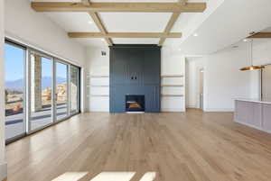 Unfurnished living room featuring beam ceiling, recessed lighting, light wood-style floors, coffered ceiling, and a fireplace