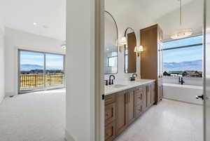 Bathroom featuring a mountain view, double vanity, and a soaking tub