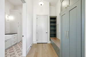 Mudroom with light wood-type flooring and baseboards