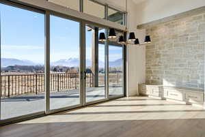 Doorway to outside with a mountain view, wood finished floors, and a chandelier