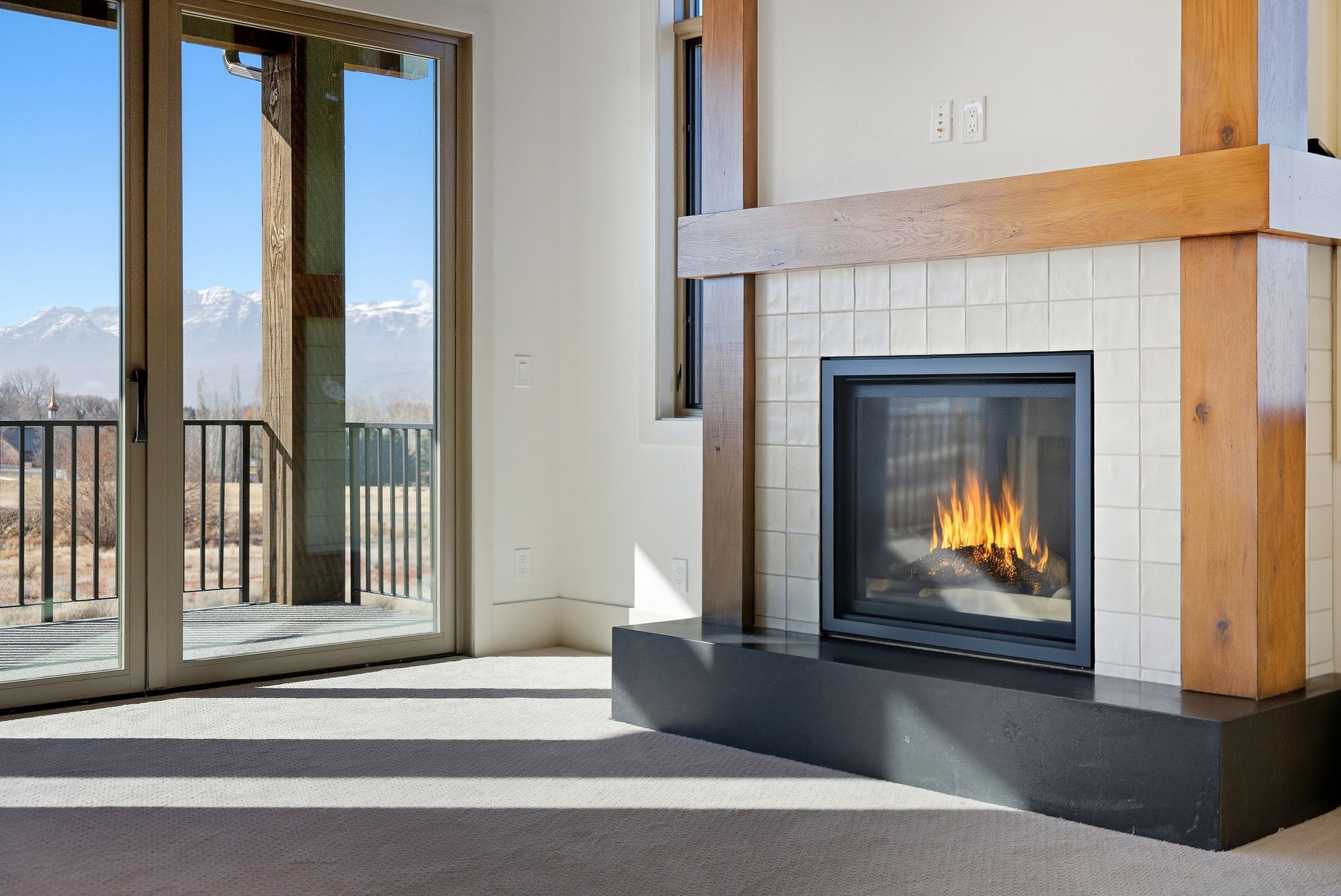Unfurnished living room featuring a glass covered fireplace and a mountain view