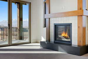 Unfurnished living room featuring a glass covered fireplace and a mountain view