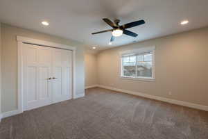 Unfurnished bedroom with carpet flooring, recessed lighting, a closet, and ceiling fan