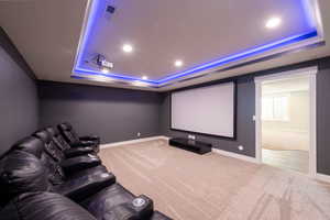 Home theater with a tray ceiling, carpet, and recessed lighting