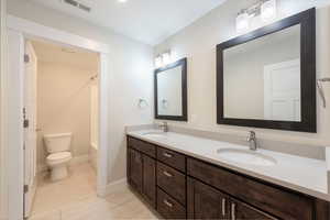 Bathroom featuring double vanity and bathing tub / shower combination