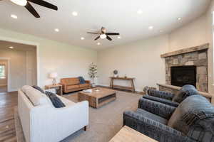 Living area featuring ceiling fan, recessed lighting, a stone fireplace, and wood finished floors