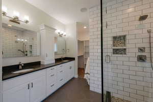Full bathroom featuring a shower stall, tile patterned floors, double vanity, and recessed lighting
