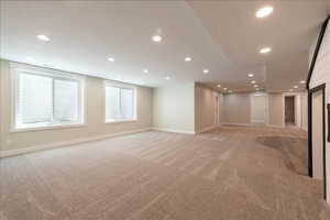 Unfurnished living room with light carpet and recessed lighting