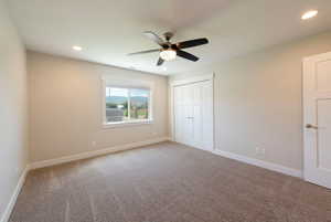 Unfurnished bedroom featuring carpet floors, a ceiling fan, recessed lighting, and a closet