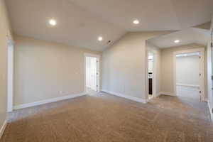 Spare room with lofted ceiling, carpet floors, and recessed lighting