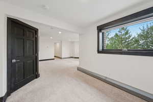 Empty room with light colored carpet, recessed lighting, and a smoke detector