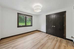 Unfurnished bedroom with light wood-style flooring and baseboards