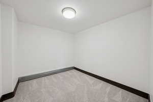 Carpeted empty room featuring baseboards