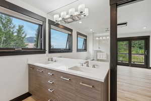 Bathroom featuring healthy amount of natural light, double vanity, wood finished floors, recessed lighting, and a shower