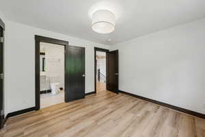 Unfurnished bedroom with light wood-type flooring and ensuite bath