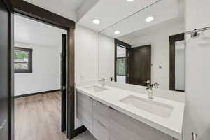 Full bath featuring double vanity, wood finished floors, and recessed lighting