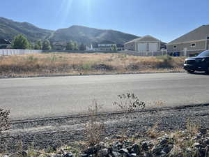 View of asphalt street featuring a mountain view