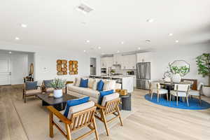 Living room with light wood finished floors and recessed lighting. pic of model home of same floor plan, actual home may vary slightly on flooring, colors, cabinets, etc.