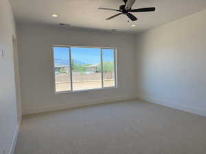 Unfurnished room with light colored carpet, recessed lighting, a ceiling fan, and a mountain view