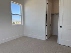Unfurnished bedroom featuring carpet and a closet
