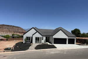 View of front of home with a garage, concrete driveway, stucco siding, and a mountain view