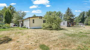 Back of house featuring a trampoline and a yard