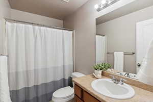 Full bath with vanity, a textured ceiling, and a shower with curtain
