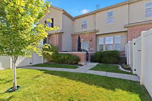 Private Backyard. View of front of house featuring brick siding and stucco siding