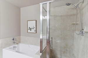 Full bath featuring a stall shower and a garden tub