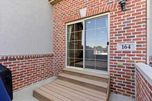 Property entrance featuring brick siding