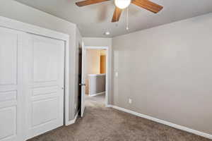 Unfurnished bedroom with carpet flooring, a closet, and a ceiling fan