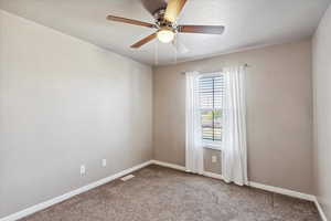 Spare room featuring carpet flooring and ceiling fan