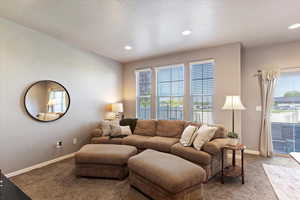 Carpeted living room with baseboards and recessed lighting