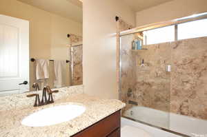 Bathroom with vanity and shower / bath combination with glass door