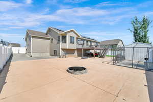 Rear view of property with a fire pit, a fenced backyard, a patio, a shed, and stairway