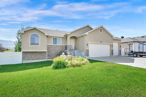 Ranch-style home featuring stucco siding, a garage, driveway, and stone siding